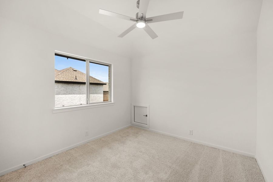 Empty bedroom with vaulted ceiling, ceiling fan, carpet flooring, and a single window