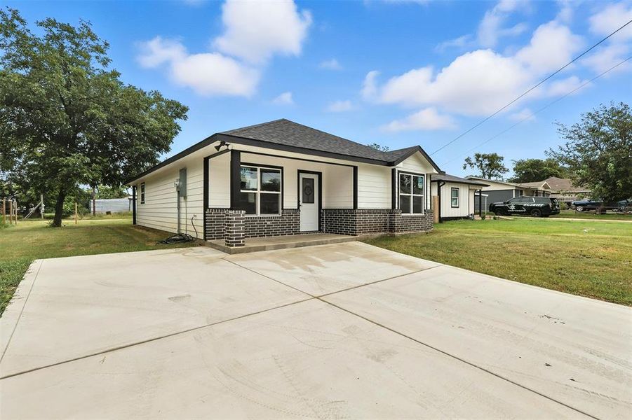 View of front of home with brick siding, driveway, roof with shingles, and a front lawn View of front of home with brick siding, driveway, roof with shingles, and a front lawn