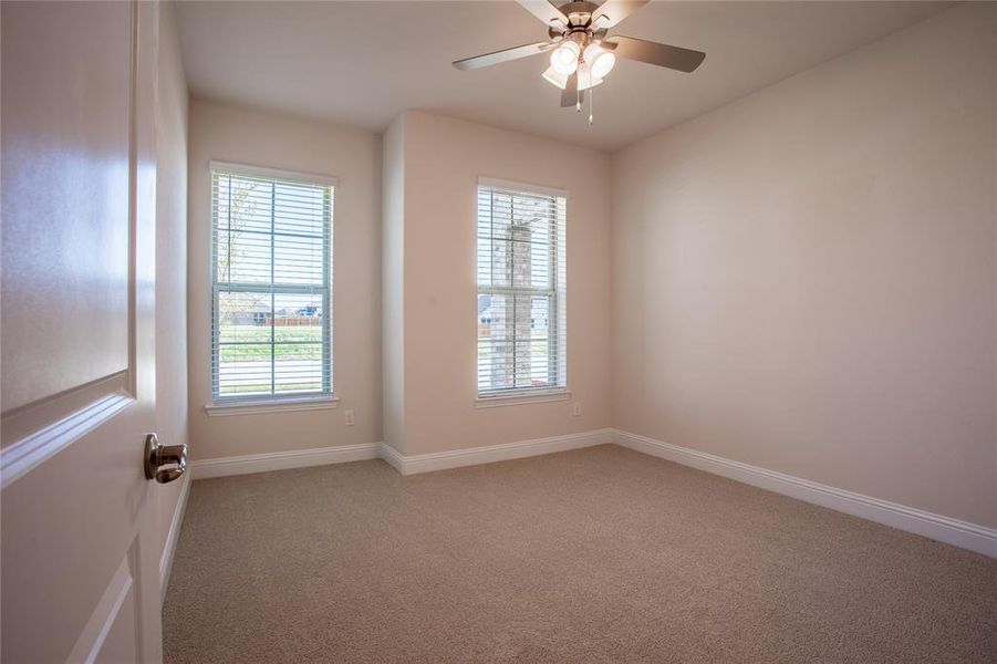 Carpeted spare room with ceiling fan