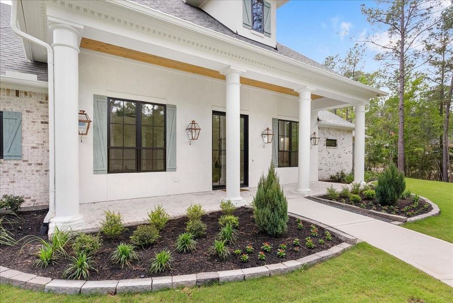 Rich herringbone brickwork, Old World mortar, and architectural columns create a timeless exterior that feels substantial, elegant, and unmistakably custom.