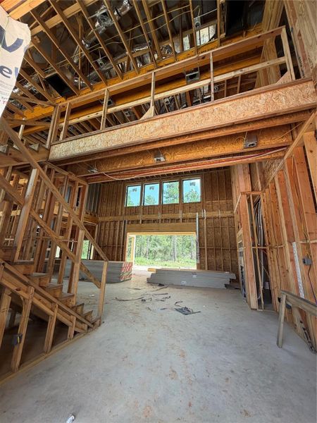 Expansive open-concept interior with high ceilings and large windows, showcasing potential for customization in this framed construction space. Expansive open-concept interior with high ceilings and large windows, showcasing potential for customization in this framed construction space.