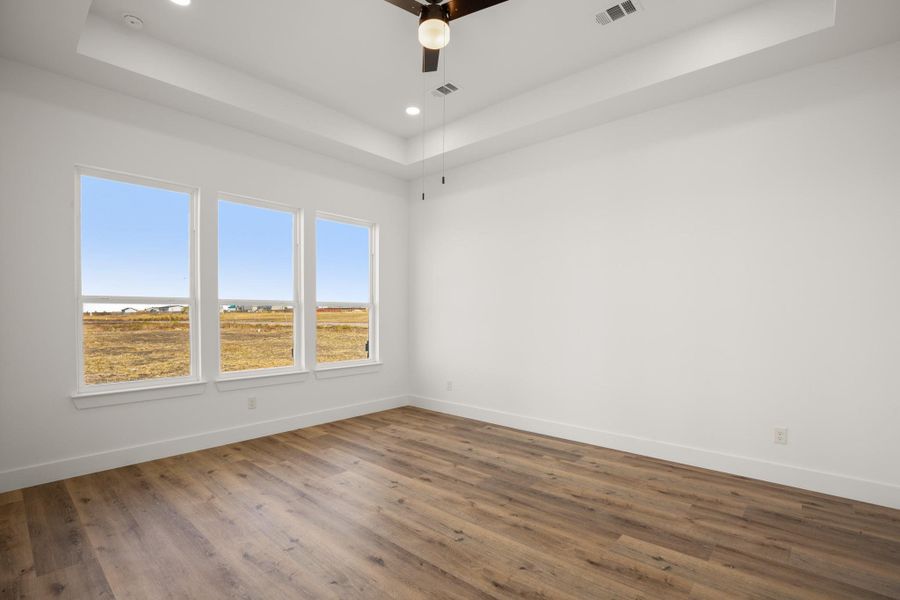 A tranquil bedroom with wide-plank flooring and expansive windows offers sweeping views of the surrounding landscape. A tranquil bedroom with wide-plank flooring and expansive windows offers sweeping views of the surrounding landscape.