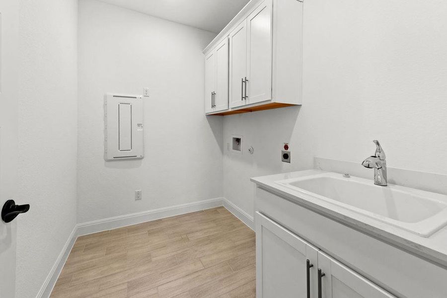 Utility room with sink and cabinetry