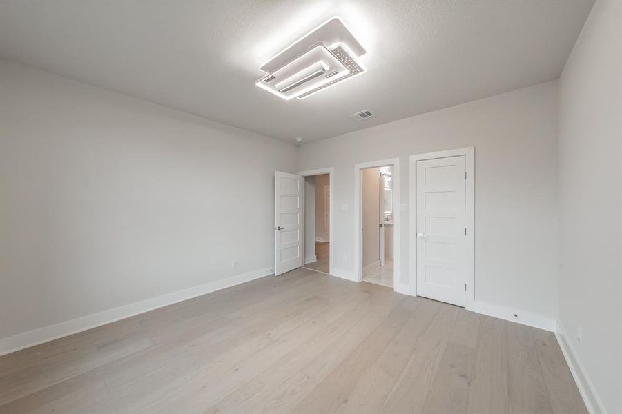 Unfurnished bedroom featuring light wood finished floors and a closet