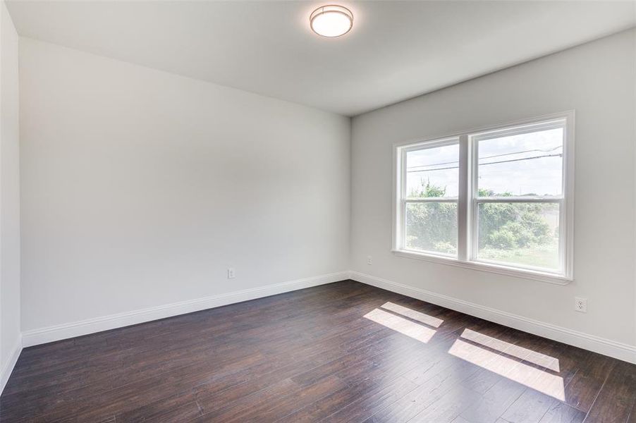 Spare room featuring dark wood-type flooring