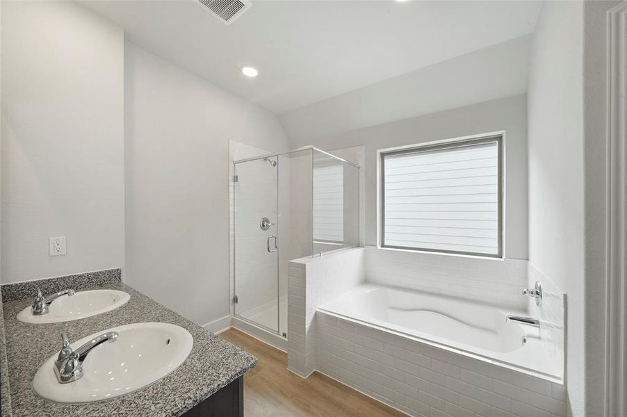 Primary bathroom with double sinks, standalone shower and tub