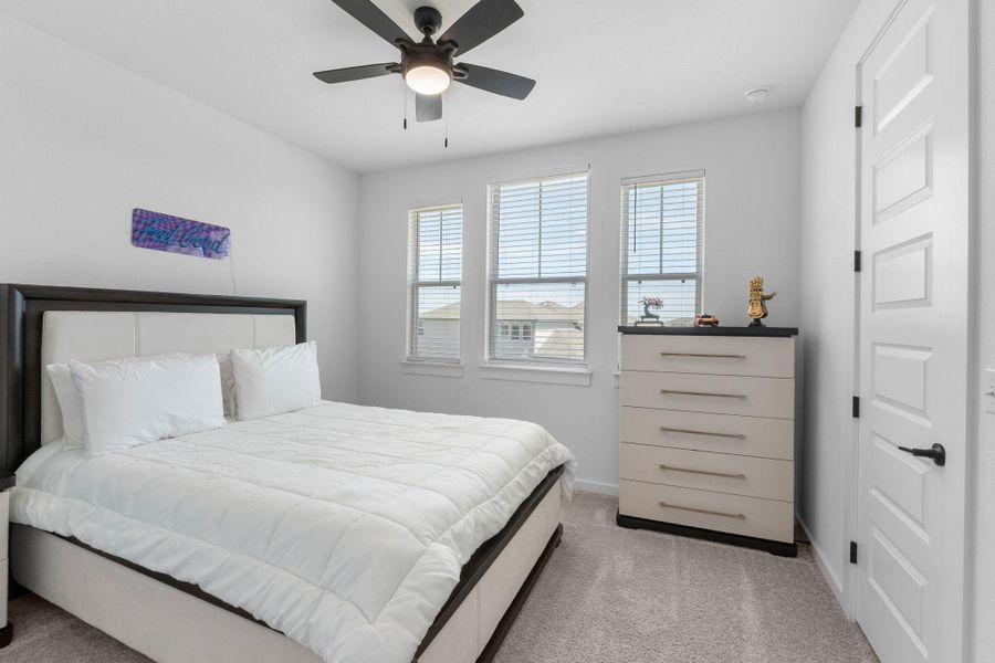 Bedroom 4 featuring baseboards, light colored carpet, and a ceiling fan