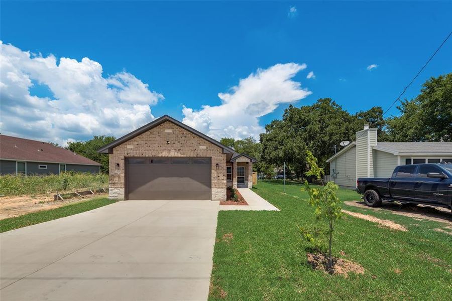 View of front of house featuring a garage and a front lawn