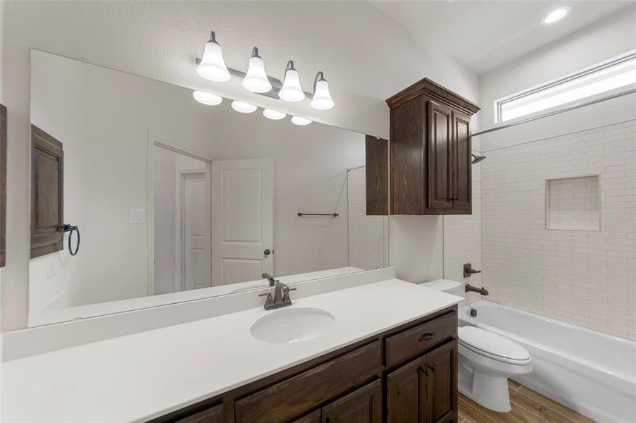 Full bathroom featuring vanity, bathtub / shower combination, and wood finish floors Full bathroom featuring vanity, bathtub / shower combination, and wood finish floors