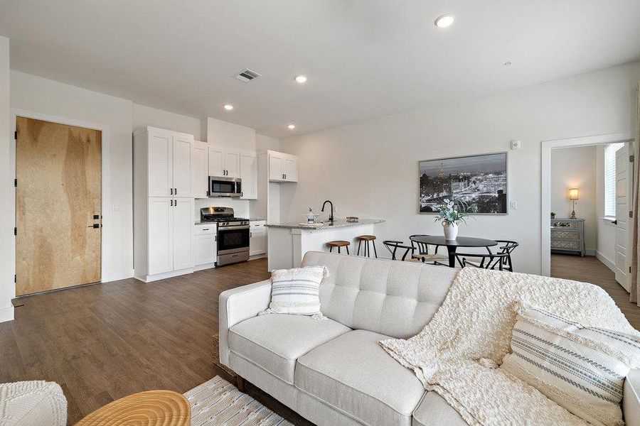 Living area featuring dark wood finished floors and recessed lighting