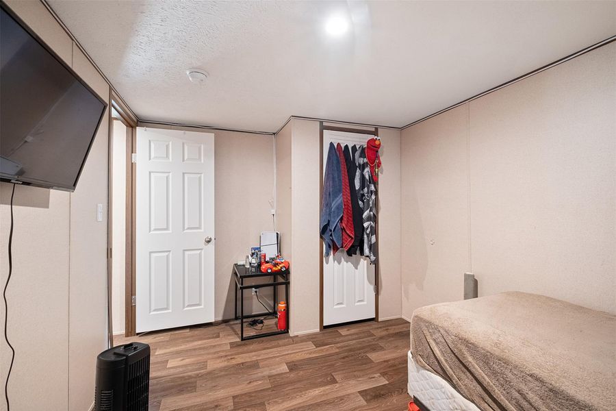 Bedroom featuring wood finished floors and a textured ceiling