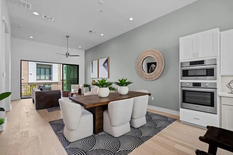 An open floorplan connects the dining area to the living space with light hardwood flooring. An open floorplan connects the dining area to the living space with light hardwood flooring.