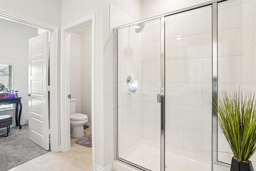 Bathroom with a shower stall and light tile patterned flooring Bathroom with a shower stall and light tile patterned flooring