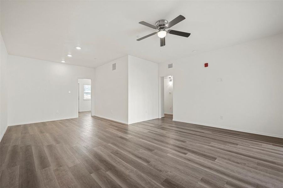 Living room featuring ceiling fan and dark wood-type flooring