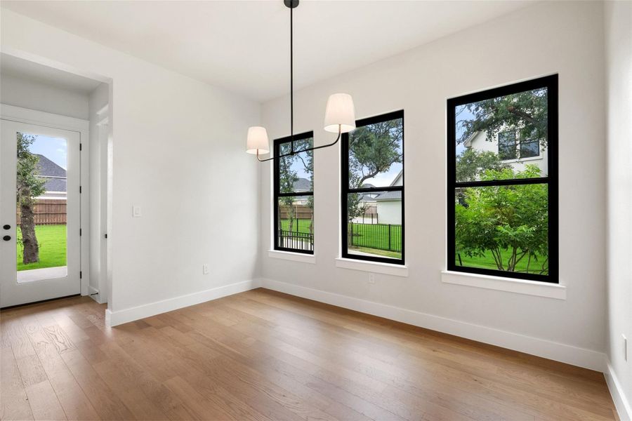 Hardwood flooring extends throughout this light-filled room, creating a seamless and inviting atmosphere.