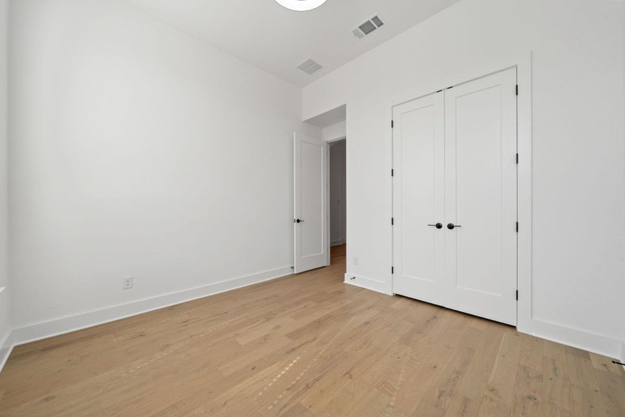 Unfurnished bedroom with light wood-type flooring and a closet