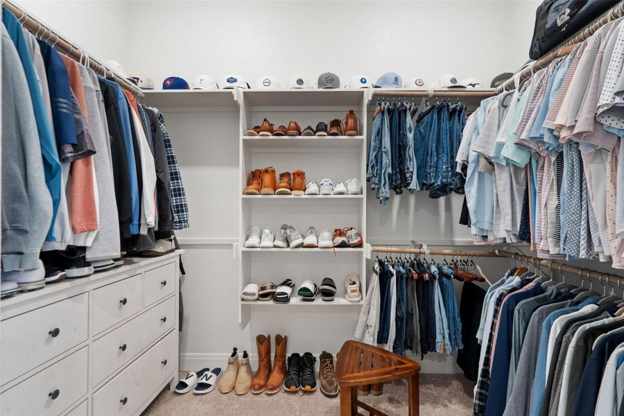 Custom shelving and hanging rods organize a well-appointed walk-in closet. Custom shelving and hanging rods organize a well-appointed walk-in closet.