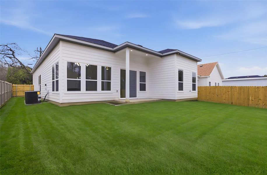 Back of house with a fenced backyard, a patio area, and roof with shingles