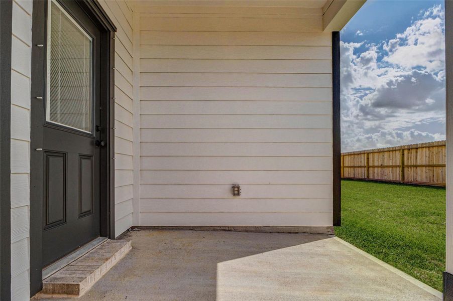 Enjoy outdoor living year-round on this covered patio, offering a shaded space perfect for relaxing or entertaining. The durable concrete surface provides plenty of room for seating or a grill setup, while the exterior siding and private backyard access create a comfortable and functional extension of the home. This space is ideal for morning coffee, evening gatherings, or simply enjoying the outdoors.