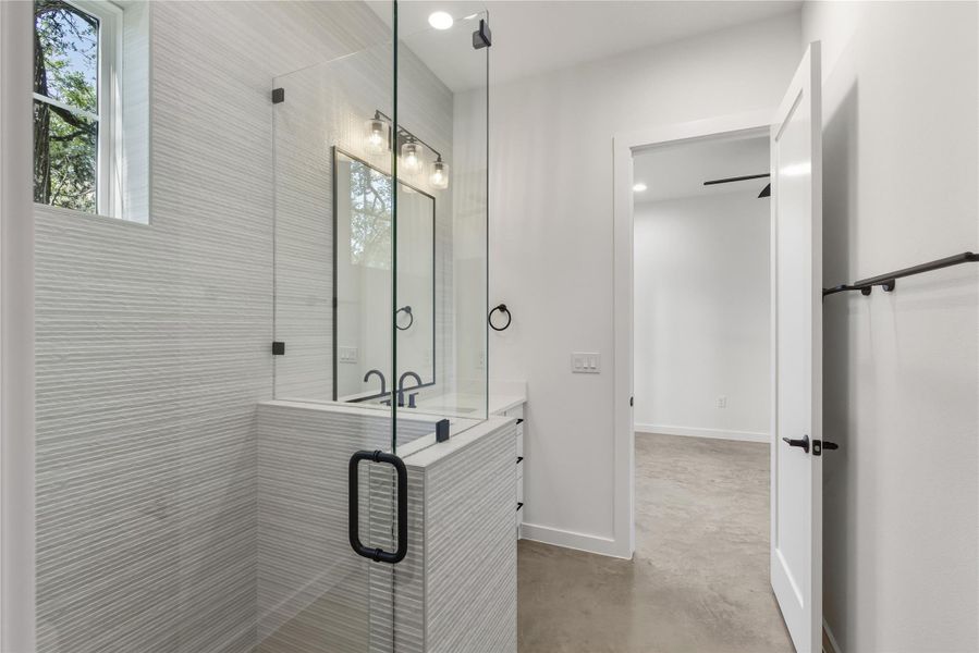 Junior suite Bathroom with finished concrete floors, vanity, a shower stall, healthy amount of natural light, and recessed lighting Junior suite Bathroom with finished concrete floors, vanity, a shower stall, healthy amount of natural light, and recessed lighting