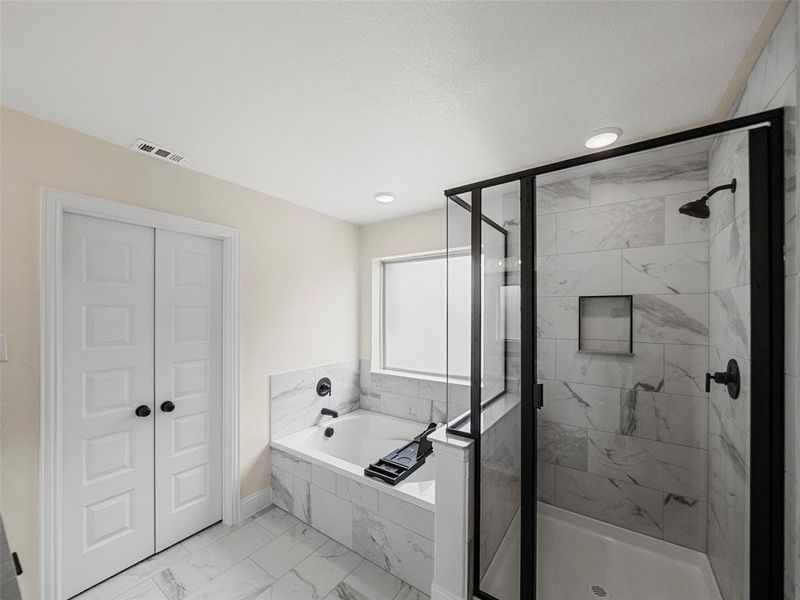 Full bath with a shower stall, marble finish flooring, and a garden tub Full bath with a shower stall, marble finish flooring, and a garden tub