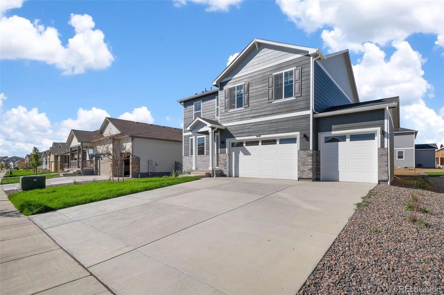 Front exterior of a new home in Brighton Crossing, Brighton, CO, highlighting curb appeal (Image 2).
