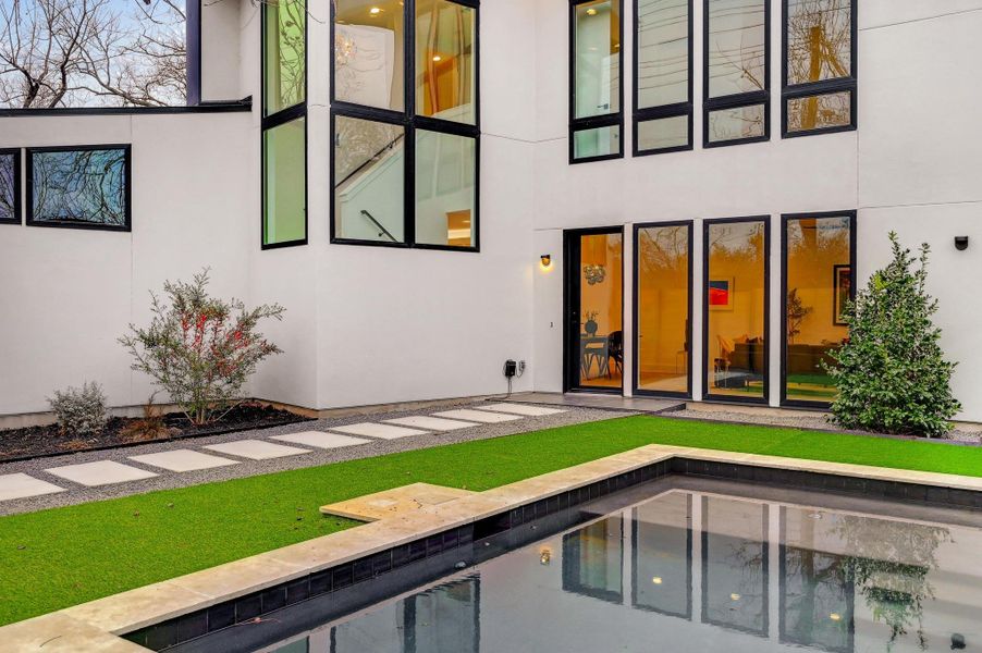 Rear view of property with an outdoor pool, stucco siding, and a patio area