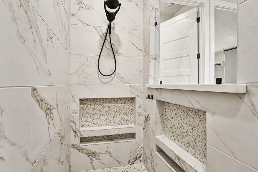 Gorgeous primary shower with added niches and upgraded showerhead. Gorgeous primary shower with added niches and upgraded showerhead.