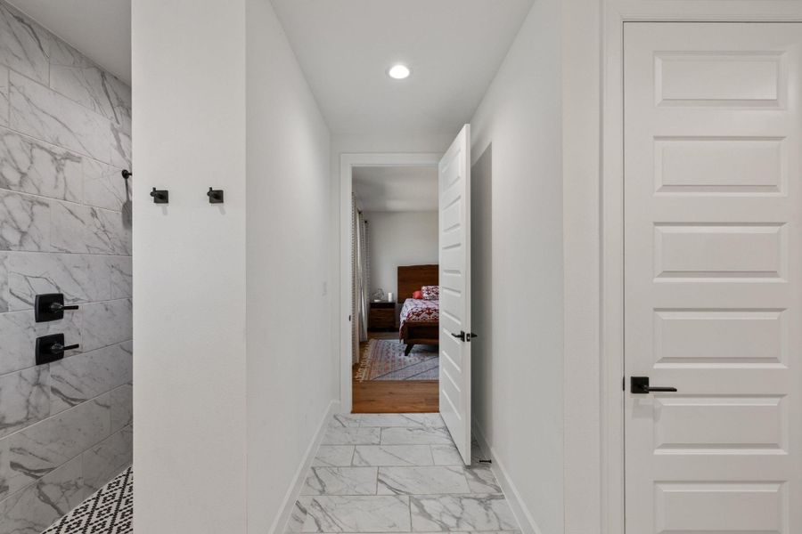Hallway featuring light marble finish flooring and recessed lighting