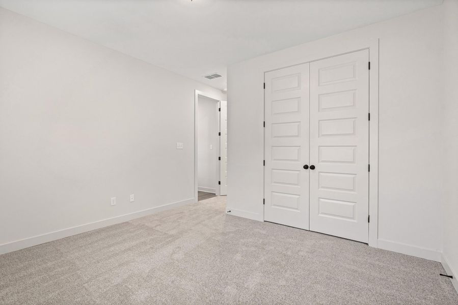 Spacious room featuring light gray carpeting and white walls Spacious room featuring light gray carpeting and white walls