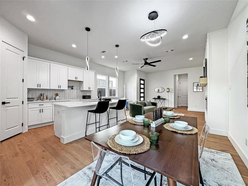 Dining room featuring a ceiling fan, light wood-style floors, recessed lighting, baseboards, and a chandelier