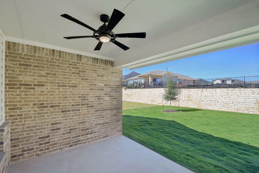 Fenced backyard featuring a patio and ceiling fan