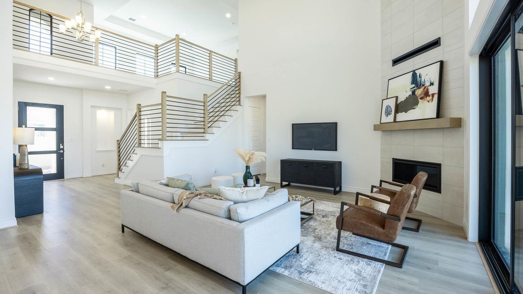 Living area with a high ceiling, baseboards, stairs, and wood finished floors Living area with a high ceiling, baseboards, stairs, and wood finished floors