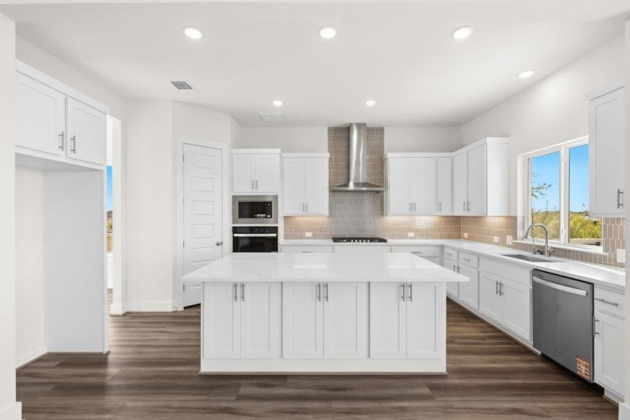 Kitchen with white cabinetry, decorative backsplash, recessed lighting, a center island, and dark wood-style floors Kitchen with white cabinetry, decorative backsplash, recessed lighting, a center island, and dark wood-style floors