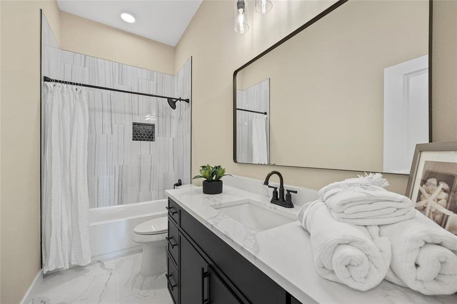 Full bathroom with vanity, shower / bath combination with curtain, and toilet