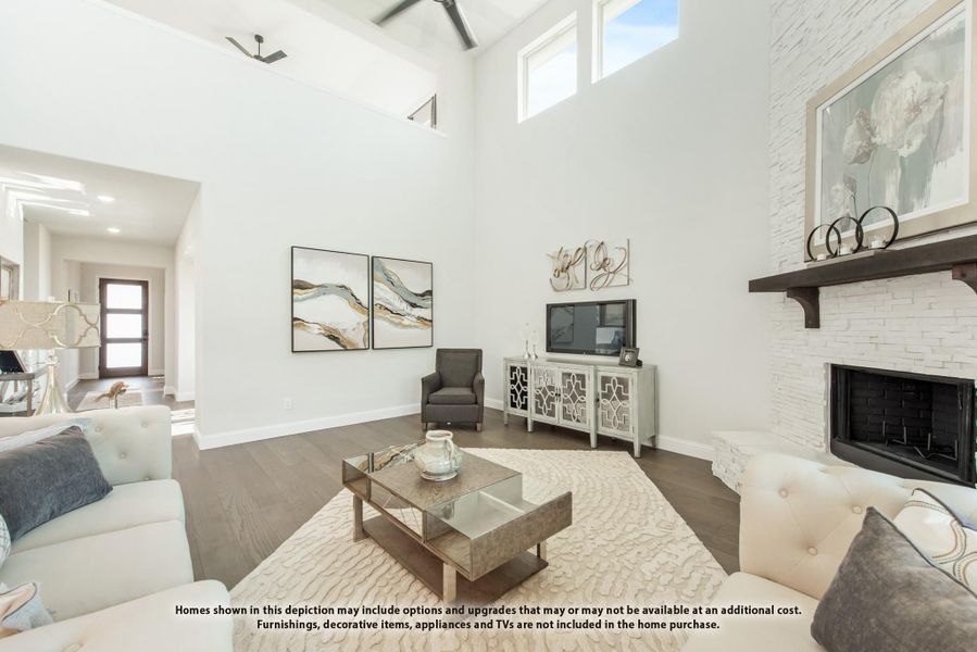 Living room with two-story ceiling, white stone fireplace, and hardwood floors Living room with two-story ceiling, white stone fireplace, and hardwood floors