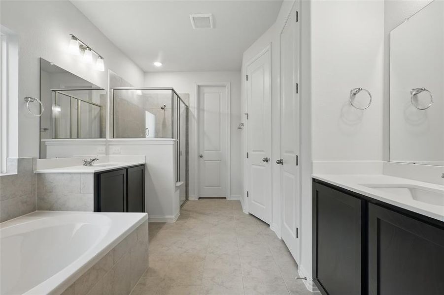 Bathroom with a shower stall, a garden tub, and two vanities Bathroom with a shower stall, a garden tub, and two vanities