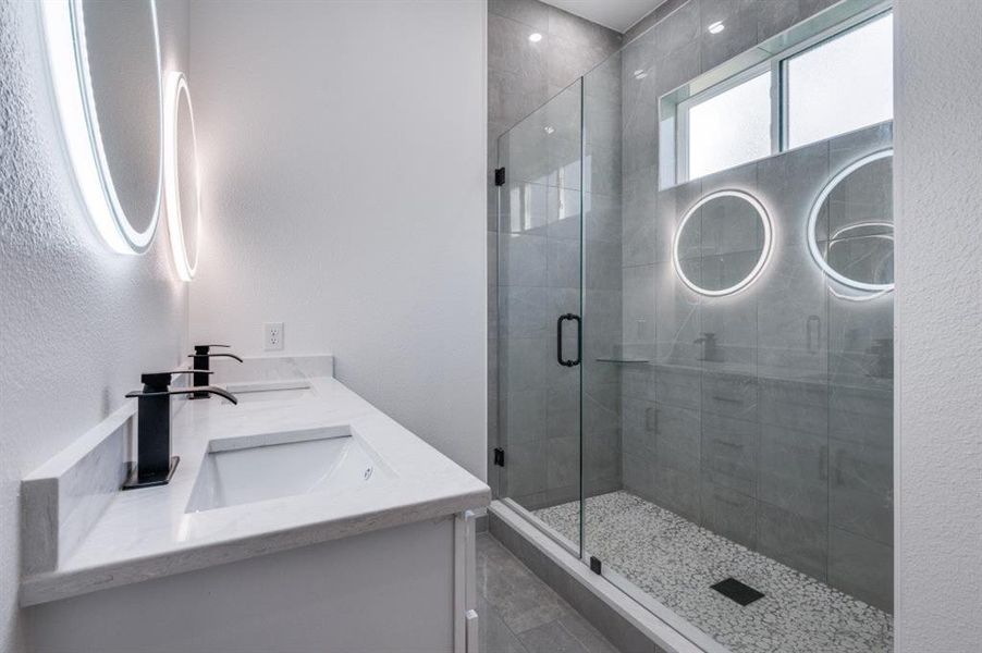 Bathroom featuring vanity and a shower with shower door