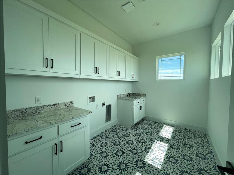 Laundry area featuring cabinet space, hookup for an electric dryer, and hookup for a washing machine Laundry area featuring cabinet space, hookup for an electric dryer, and hookup for a washing machine