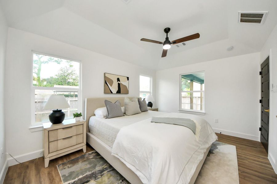 A serene, sunlit bedroom with vaulted ceilings that create an airy, restful retreat. Large windows invite in natural light, while neutral tones, a cozy bed, and simple, stylish touches complete the calm and inviting atmosphere. A serene, sunlit bedroom with vaulted ceilings that create an airy, restful retreat. Large windows invite in natural light, while neutral tones, a cozy bed, and simple, stylish touches complete the calm and inviting atmosphere.