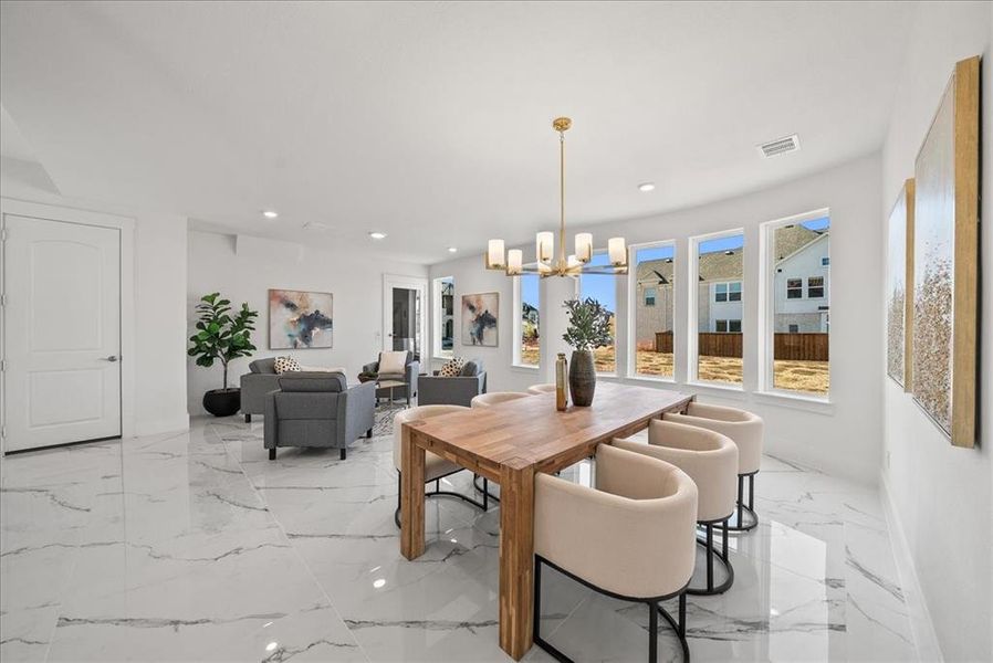 Dining area featuring a chandelier, recessed lighting, and light marble finish flooring Dining area featuring a chandelier, recessed lighting, and light marble finish flooring
