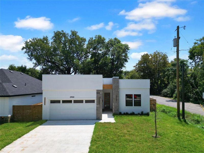 Contemporary house featuring an attached garage, stucco siding, and driveway