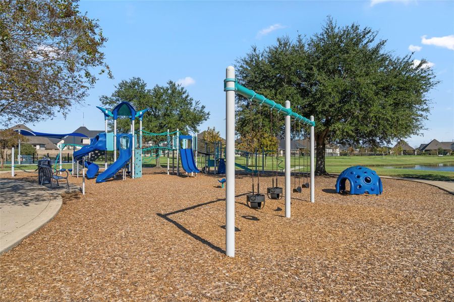 Community Playground with swings, slides, and soft landing material, fully accessible to residents.