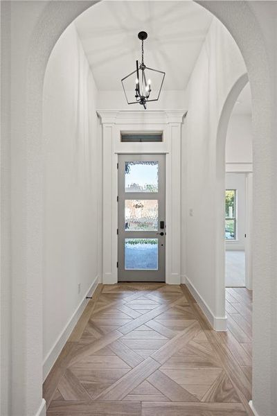 Foyer featuring arched walkways and a chandelier