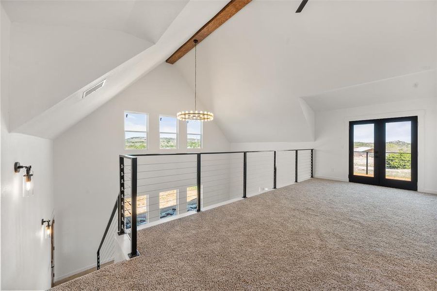 Bonus room featuring carpet, vaulted ceiling with beams, and french doors