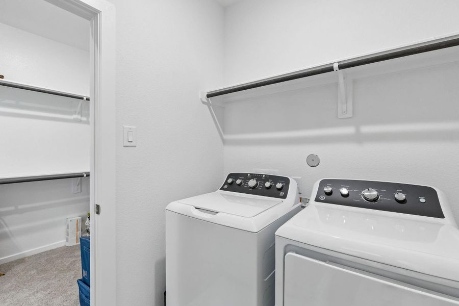 The central hallway provides access to the utility room, which is equipped with washer and electric dryer connections.