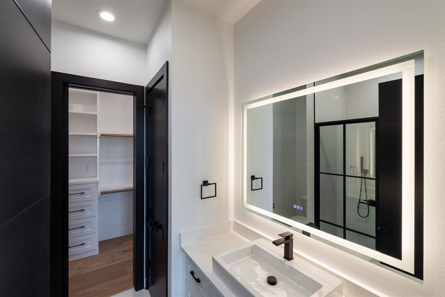 Bathroom featuring vanity, wood-type flooring, and walk in shower