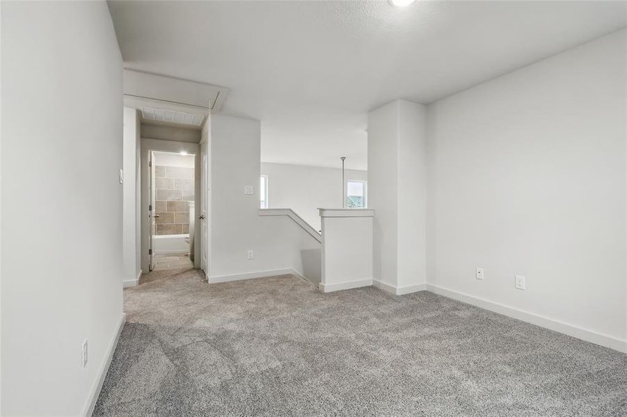 Unfurnished room featuring light carpet and baseboards