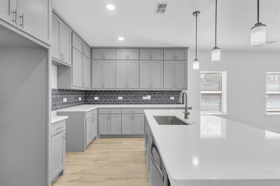 Kitchen featuring gray cabinetry, decorative backsplash, and recessed lighting