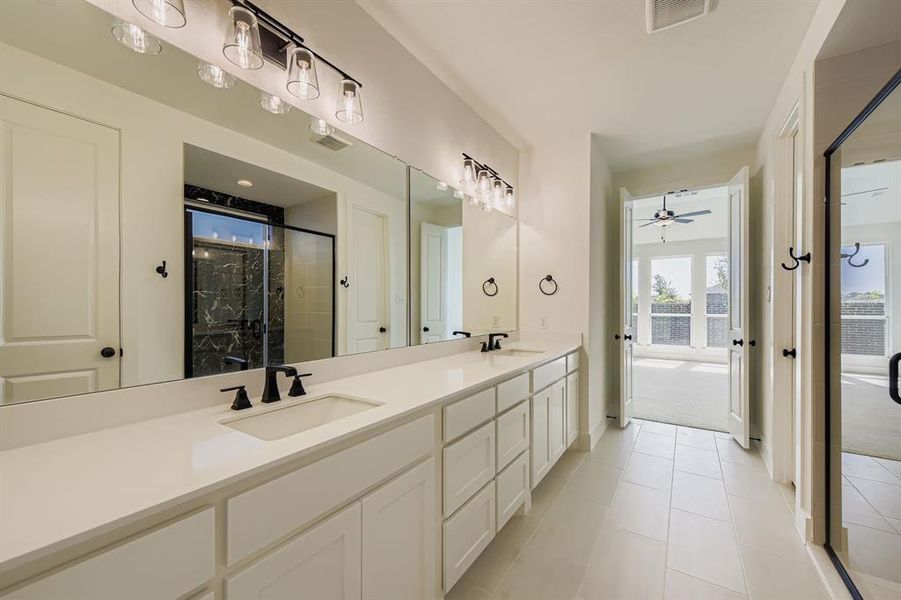 Bathroom with double vanity, a shower stall, tile patterned floors, and ceiling fan Bathroom with double vanity, a shower stall, tile patterned floors, and ceiling fan